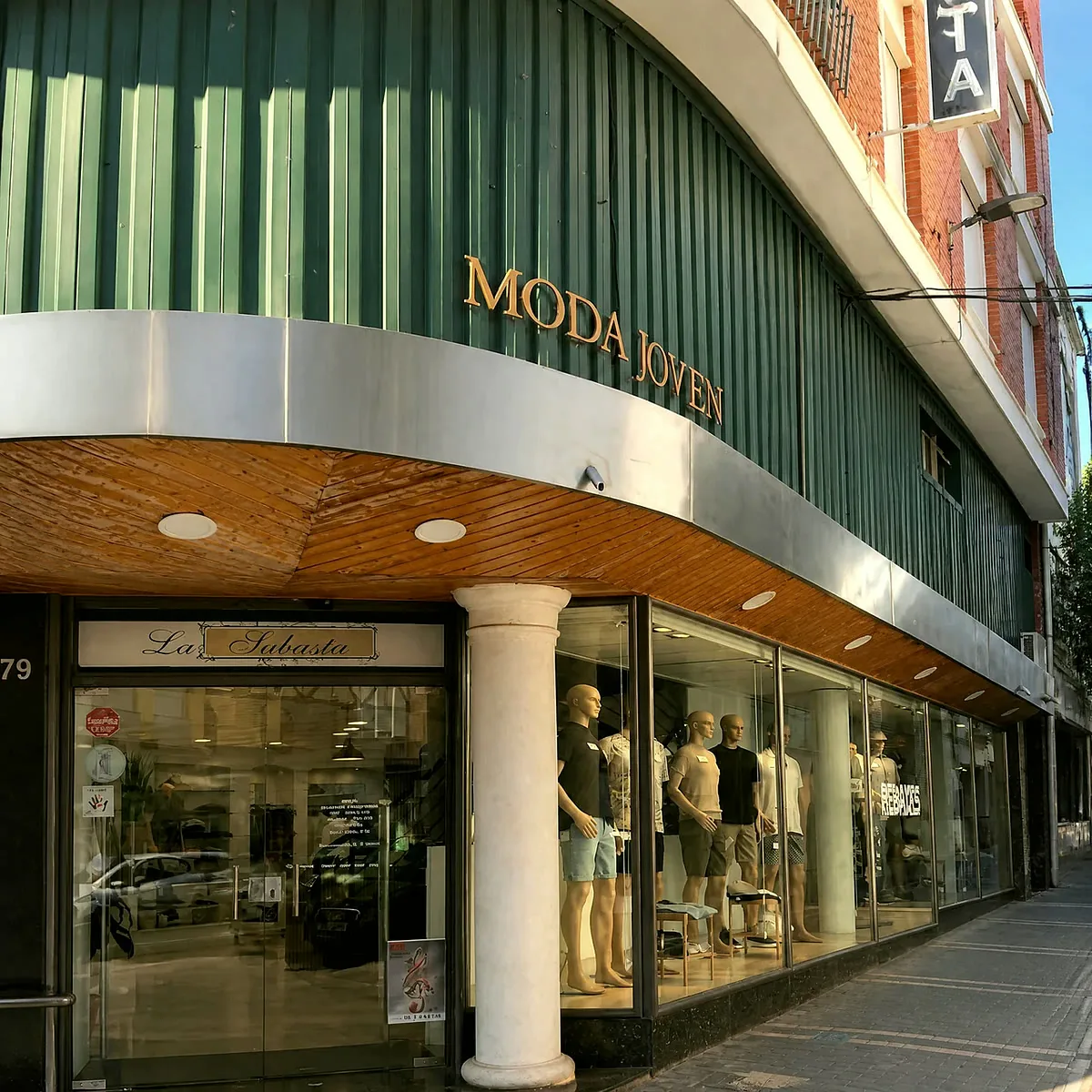 La Subasta en la esquina: el rotulo verde de MODA JOVEN, los escaparates y la entrada